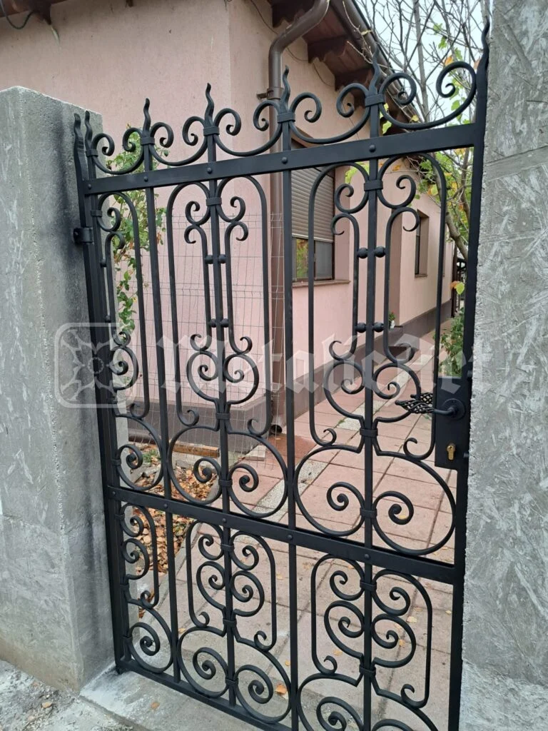 Portița și stâlpul de beton, văzute din curte.