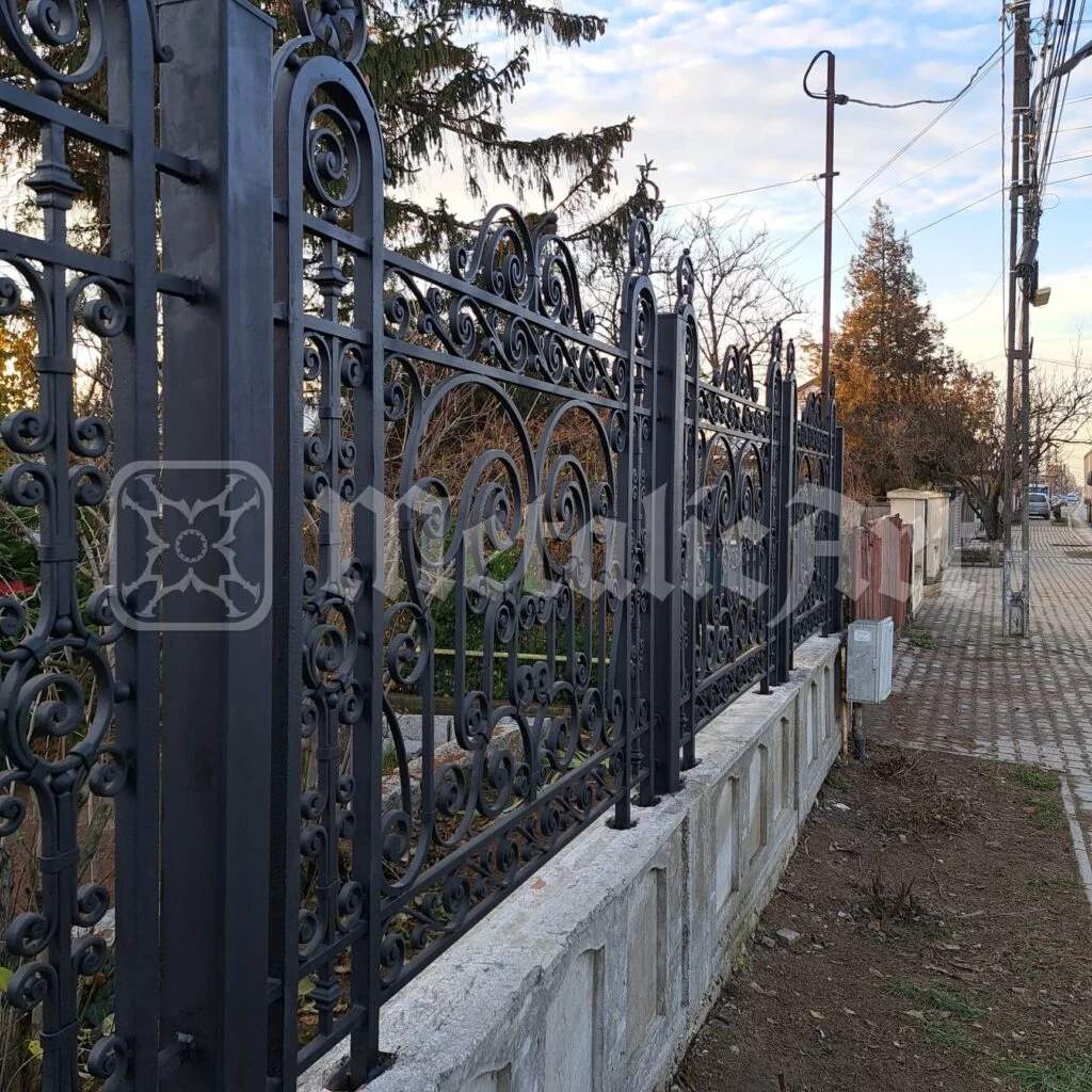 Panourile de gard de pe soclul de beton, văzute din stradă.