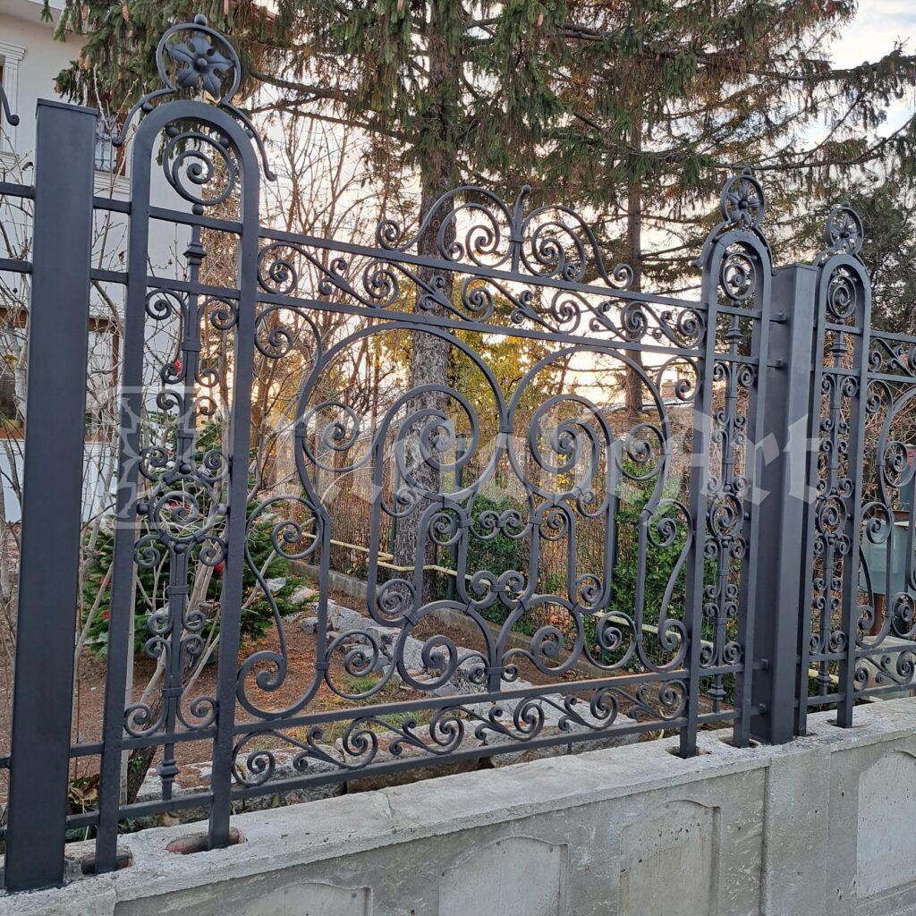 Panoul de gard dinspre grădină, cu brazii în spate.