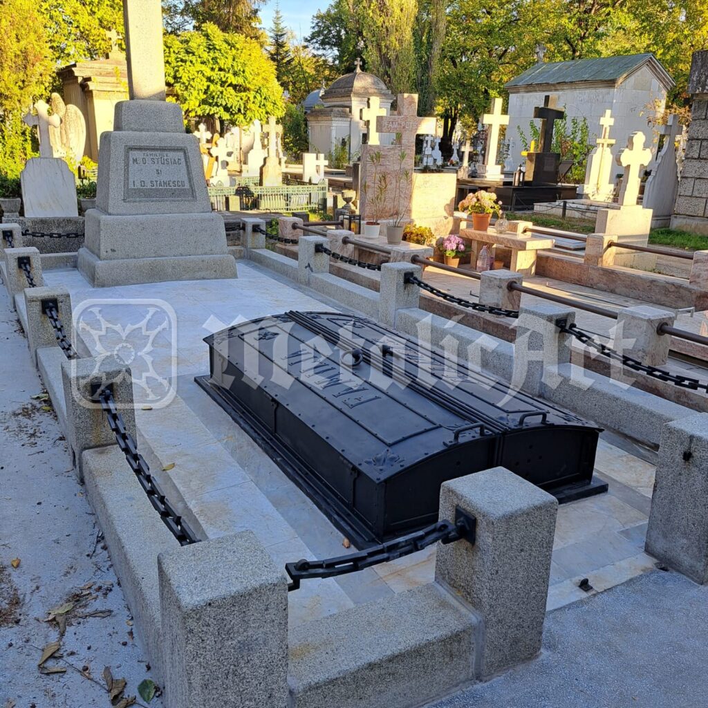 Placa de mormânt restaurată, în cimitir, între celelalte morminte.