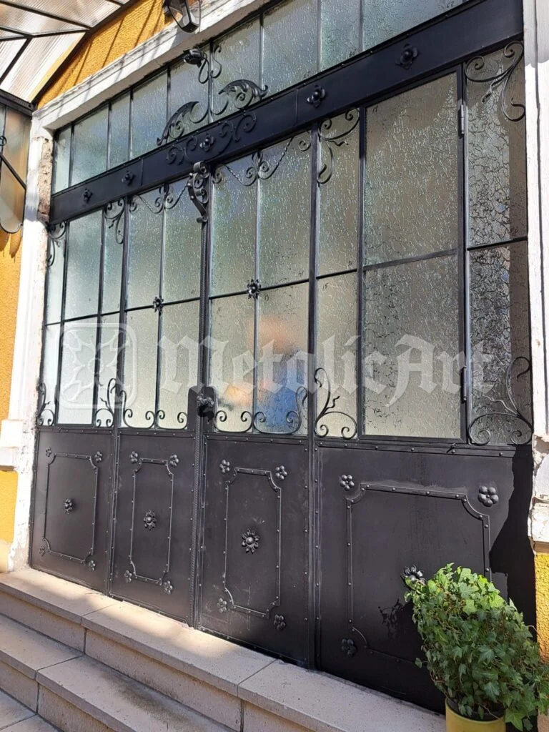 Vitrina metalică a fațadei, cu panourile pline de dedesubt.