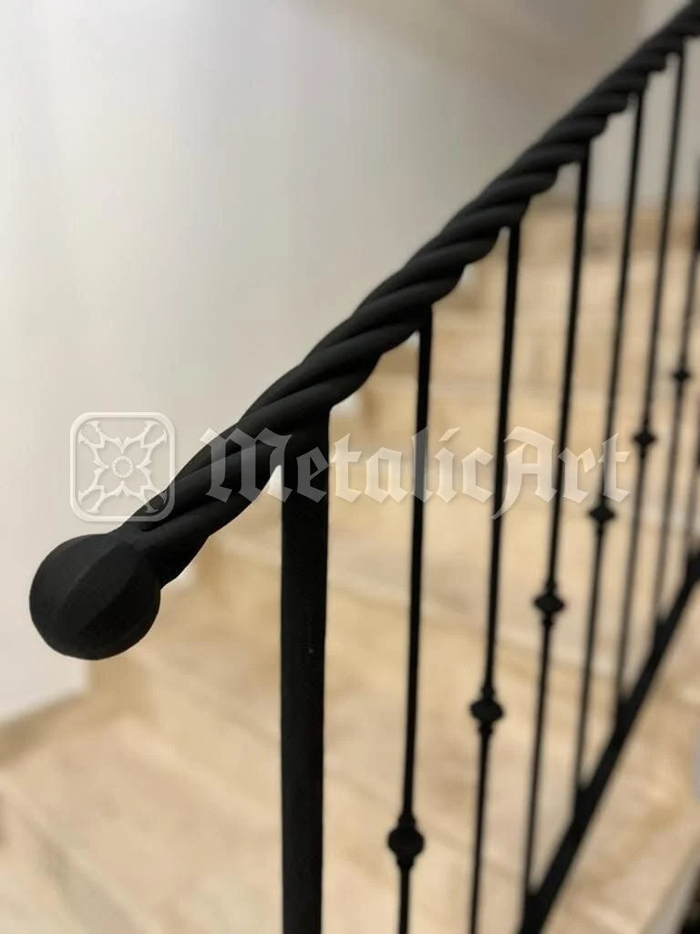 Capătul mâinii curente torsadate, deasupra treptelor.