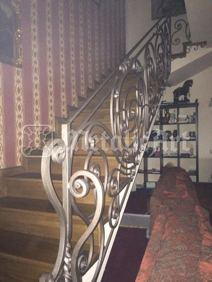 Rampa scării și raftul din spate, pe peretele vărgat.