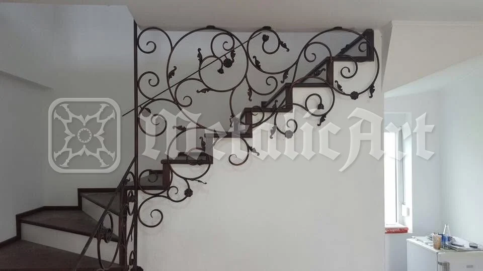 Rampa scării, pe peretele alb.