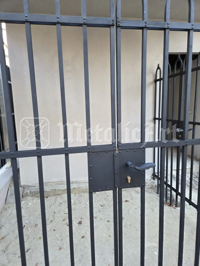 Portița din fier forjat, cu broască și mâner, închisă.