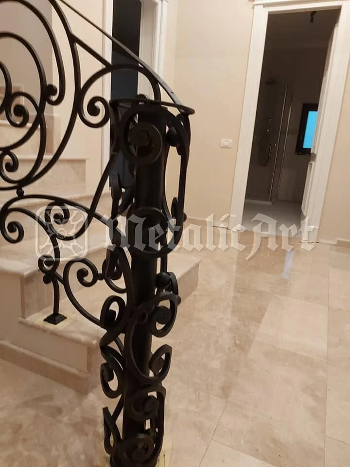 Stâlpul de pornire, cu volutele strânse în jurul lui, lângă hol.