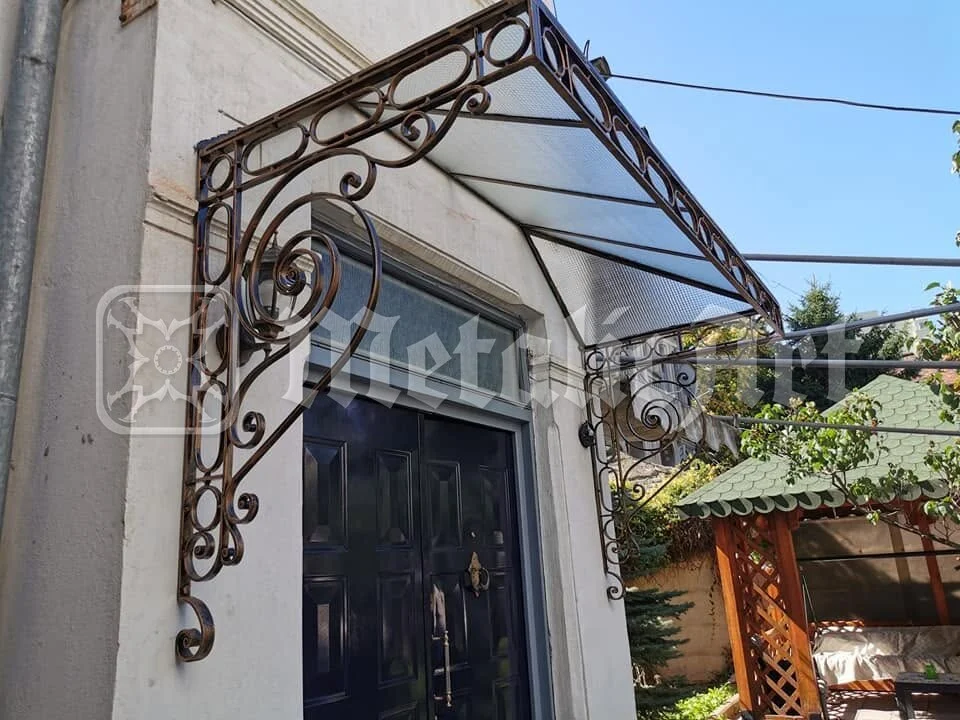 Copertina și ușa neagră, văzute dinspre grădină.