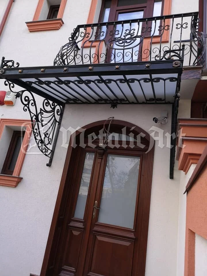 Copertina de sub balcon, deasupra ușii de lemn.