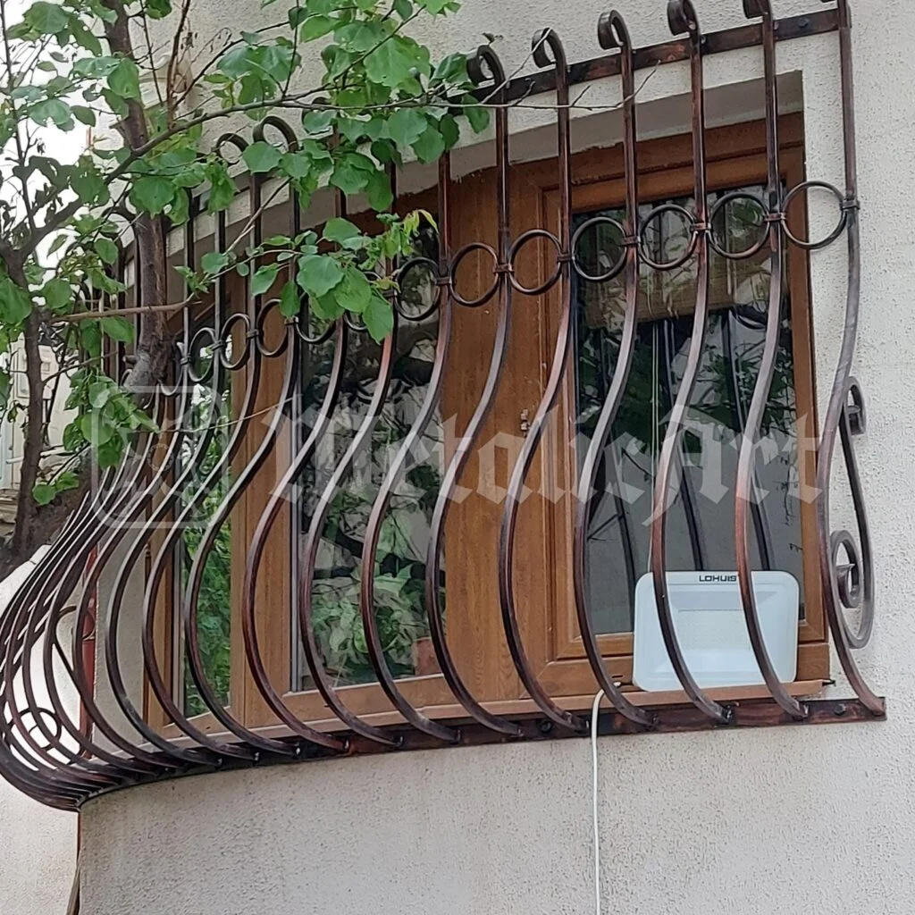 Grilajul ferestrei, văzut din față, cu vița-de-vie căzând peste el.