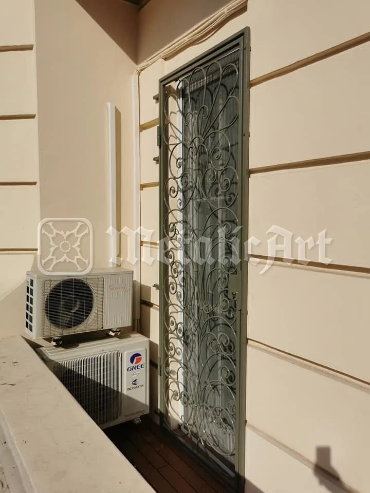 Grilajul ferestrei înalte, lângă aparatul de aer condiționat.