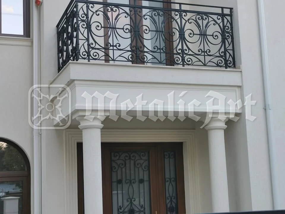 Balconul de deasupra intrării, cu balustrada lui forjată.