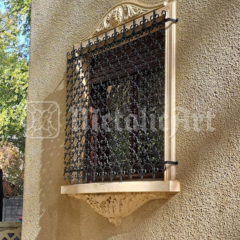 Grilajul montat pe fereastră, deasupra consolei sculptate.