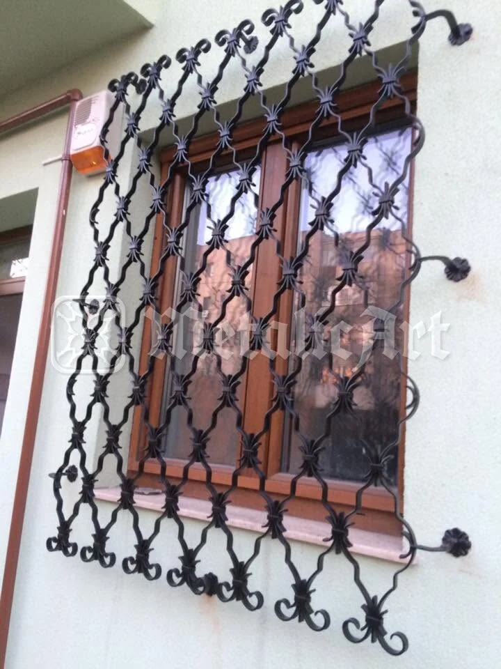 Grilajul ferestrei de la parter, cu volutele de pe ramă.