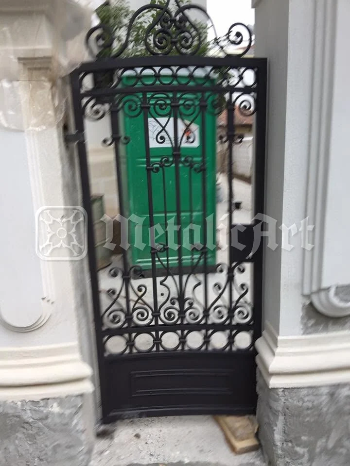 Grilajul din gang, în fața ușii verzi.