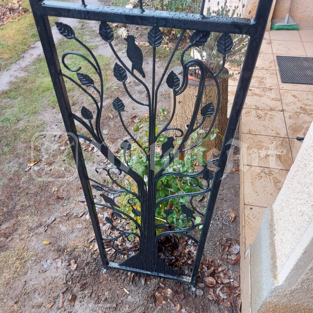 Panoul cu pomul forjat, prins între stâlpii de piatră.