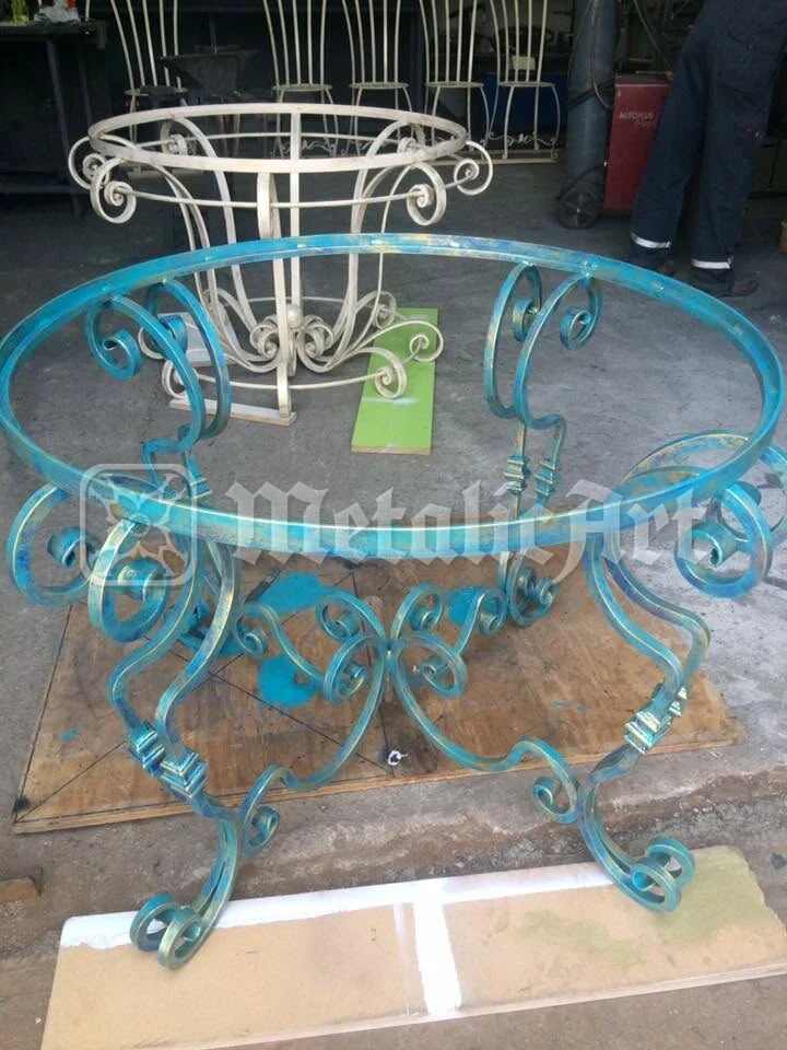Cadrul mesei pe pardoseala atelierului, lângă alte piese.
