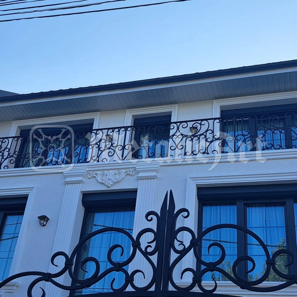 Vârful porții și balustrada balconului de deasupra.