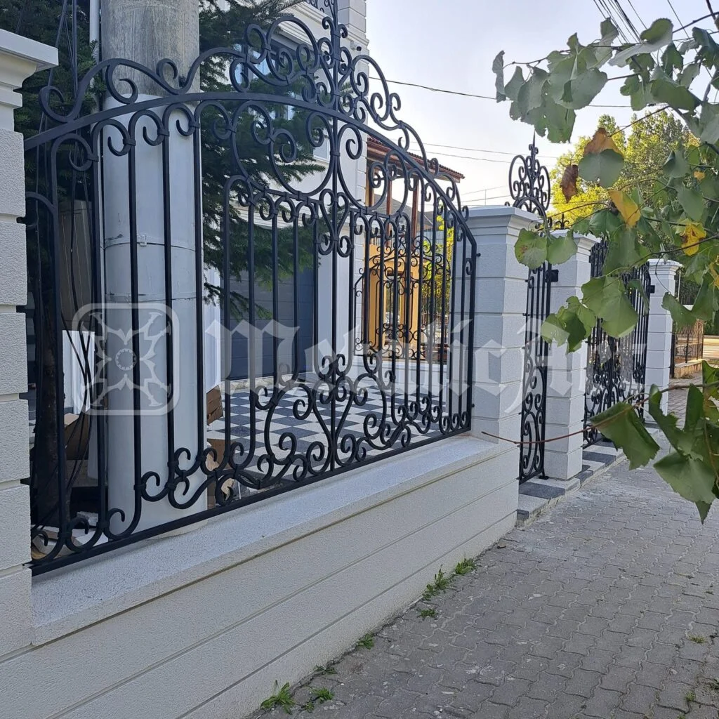 Gardul de-a lungul străzii, cu vița-de-vie deasupra.