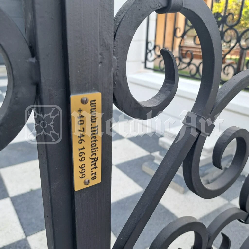 Aceeași plăcuță, văzută printre volutele porții.