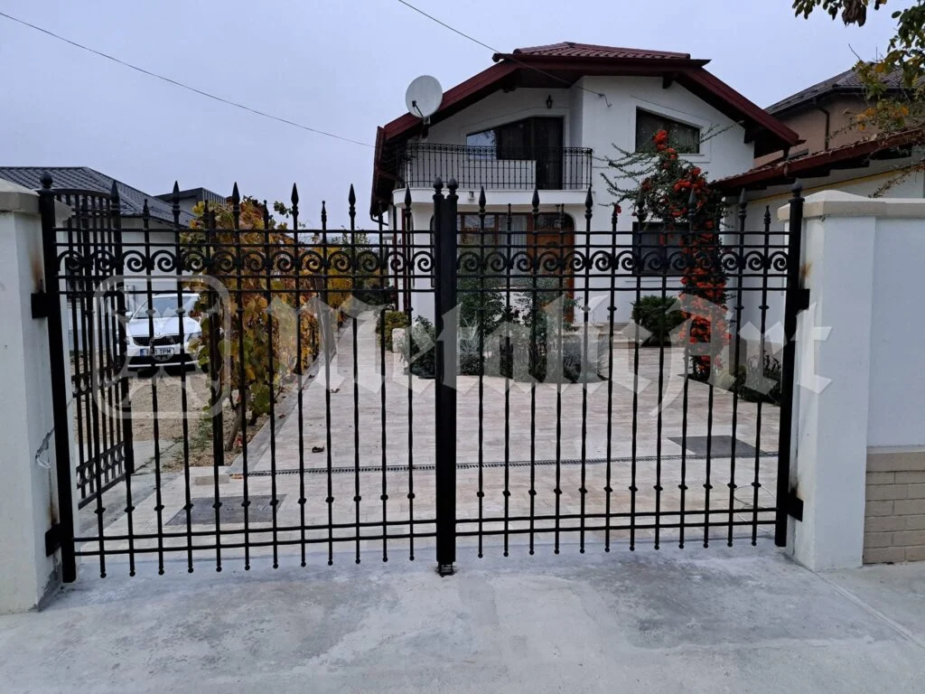 Poarta dublă cu bare verticale și vârfuri de lance, închisă, văzută din stradă