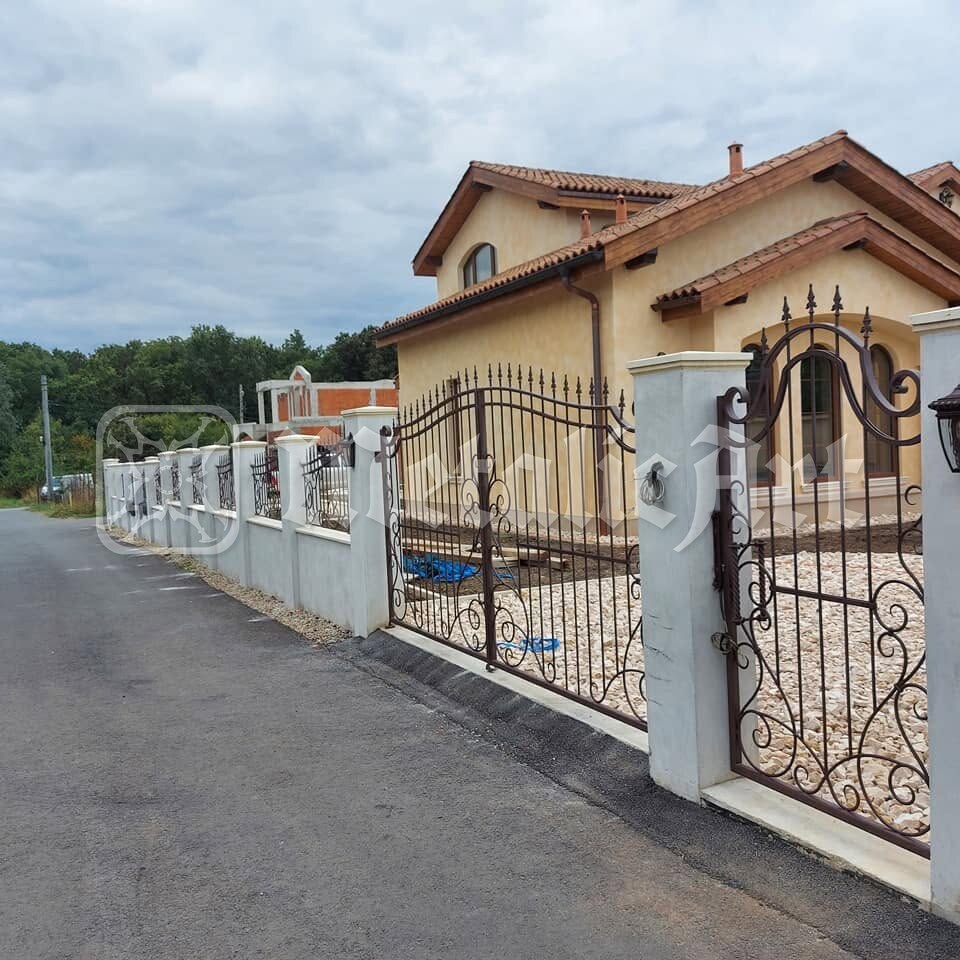 Poarta și portița, văzute din capătul drumului.