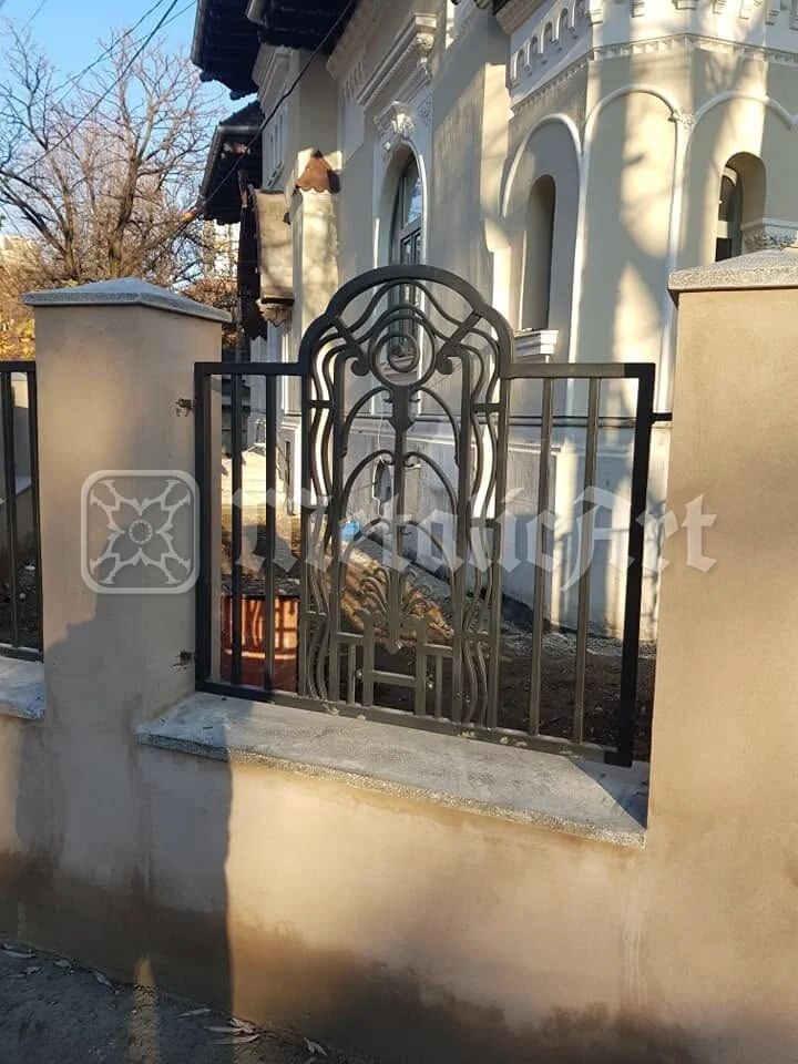 Panoul de gard cu desen Art Nouveau, pe soclul casei vechi.