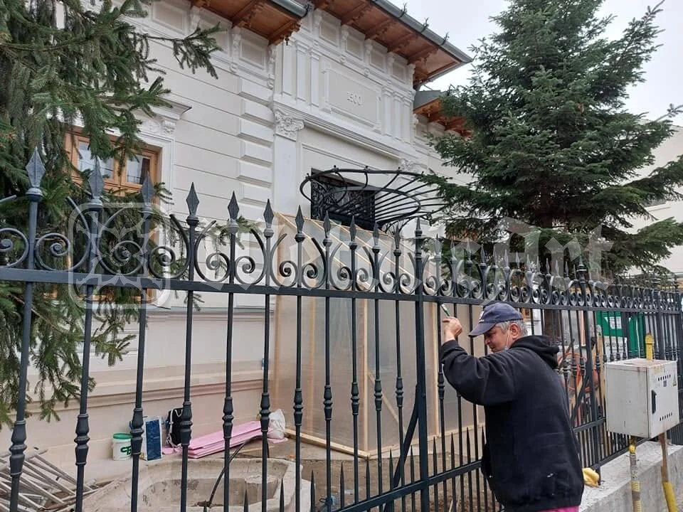 Gardul în timpul montajului, cu omul care îl prinde în stâlpi.