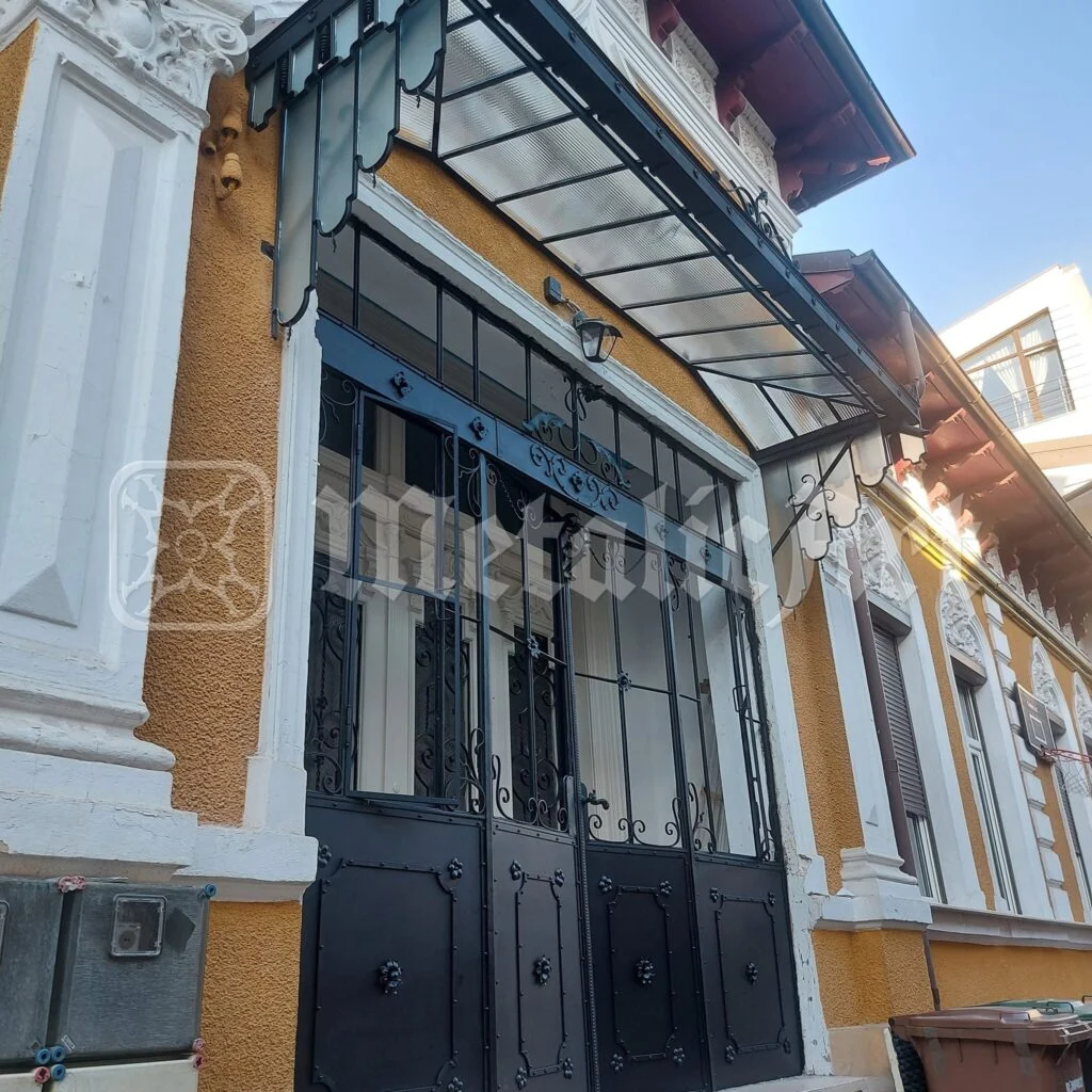 Ușa dublă și vitrina ei, văzute din stradă.