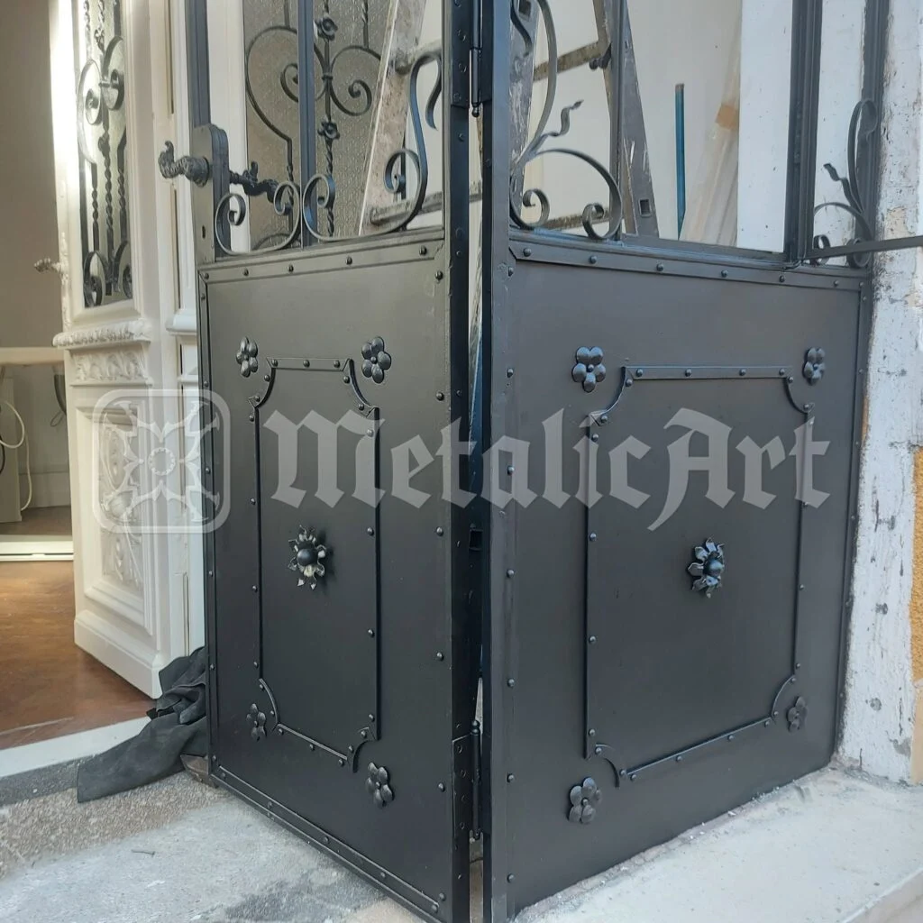 Panoul de jos al ușii, cu florile forjate, văzut din interior.
