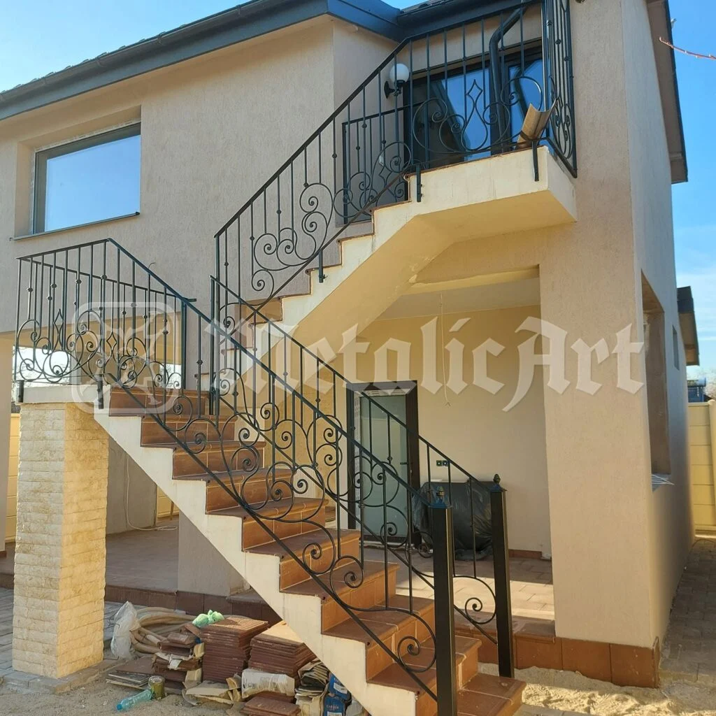 Scara exterioară care urcă la etaj, cu balustrada ei forjată.