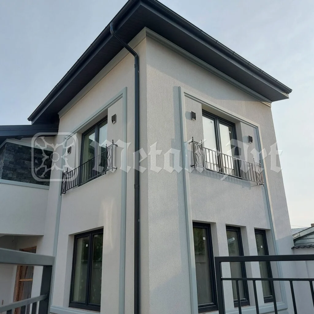 Fațada casei, cu balustradele celor două balcoane.