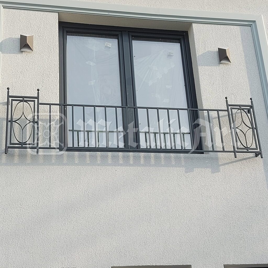 Balustrada ferestrei, cu panourile ovale de la capete.